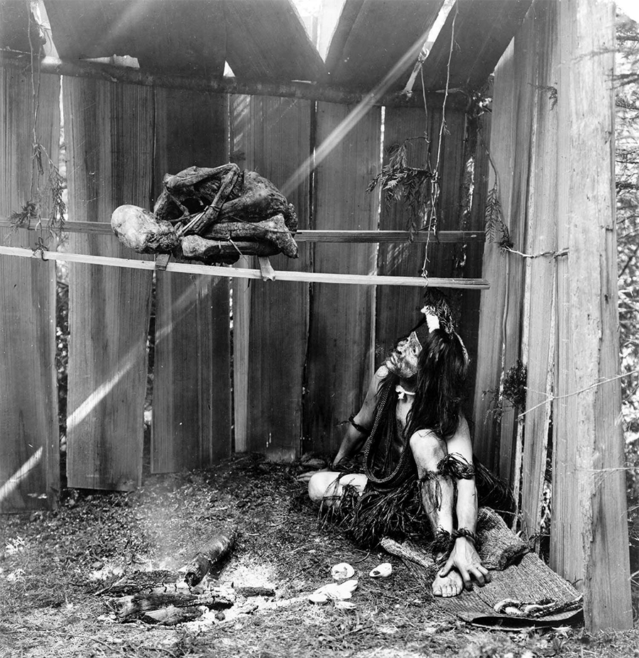 HAMATSA INITIATE IN SHED WITH BODY, 1910 HAMATSA INITIATE IN SHED WITH BODY, 1910